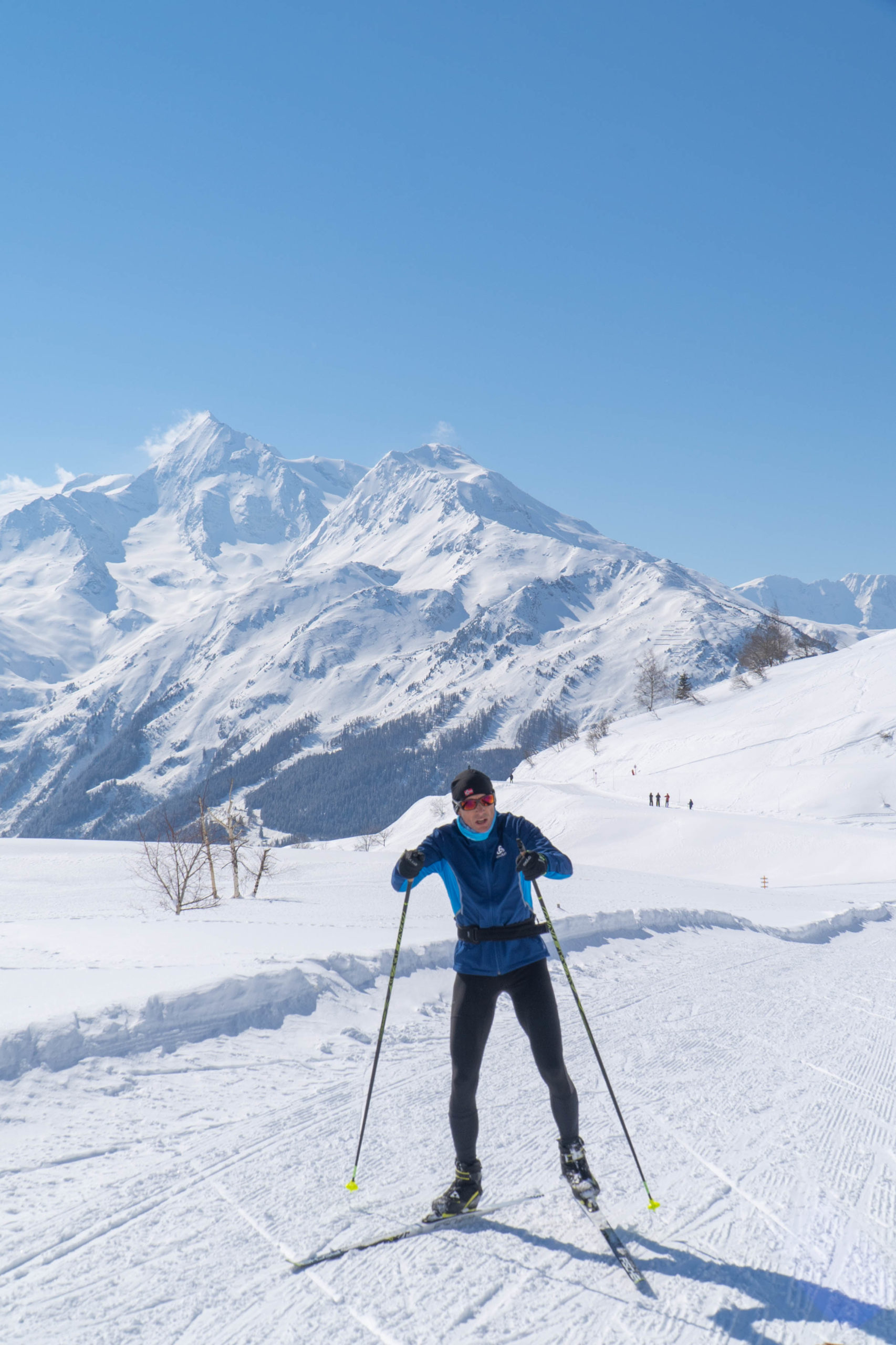 Skieur de fond avec cue dégagée sur les montagnes enneigées.